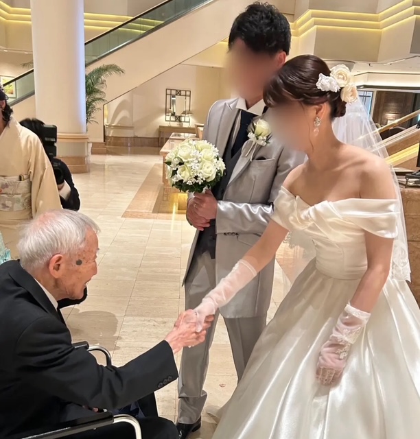 お孫様の結婚式で、新婦と握手を交わす祖父の姿