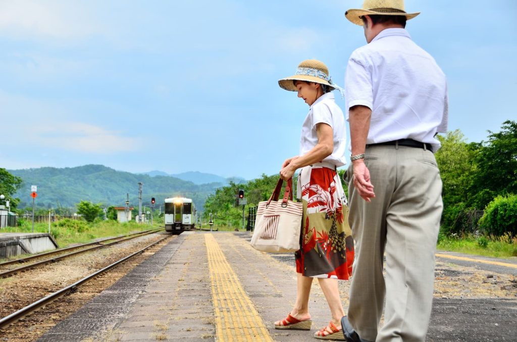 ローカルな駅のホームにて夫婦で電車を待つ様子