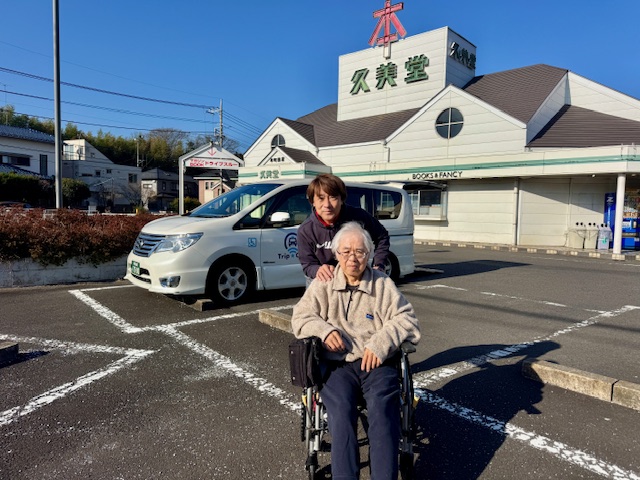 書店「久美堂」まえで車いすに乗られているお客様と記念撮影
