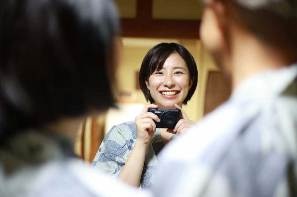 温泉旅館で、娘が両親を写真に撮っているシーン