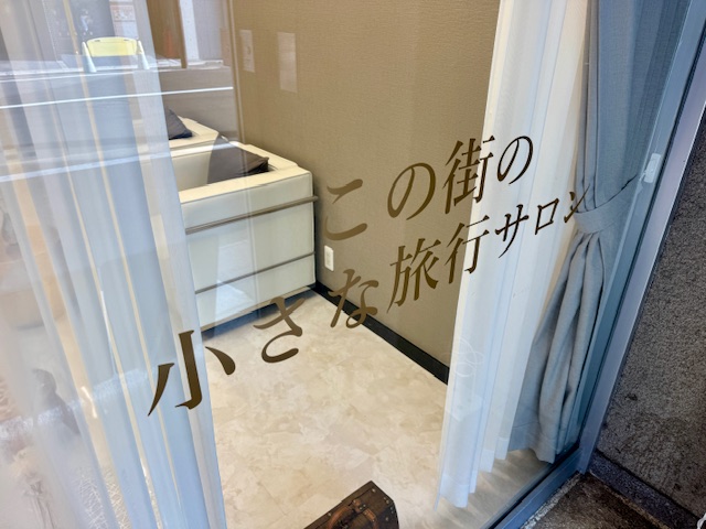店内のガラス張りには「この街の小さな旅行サロン」の案内