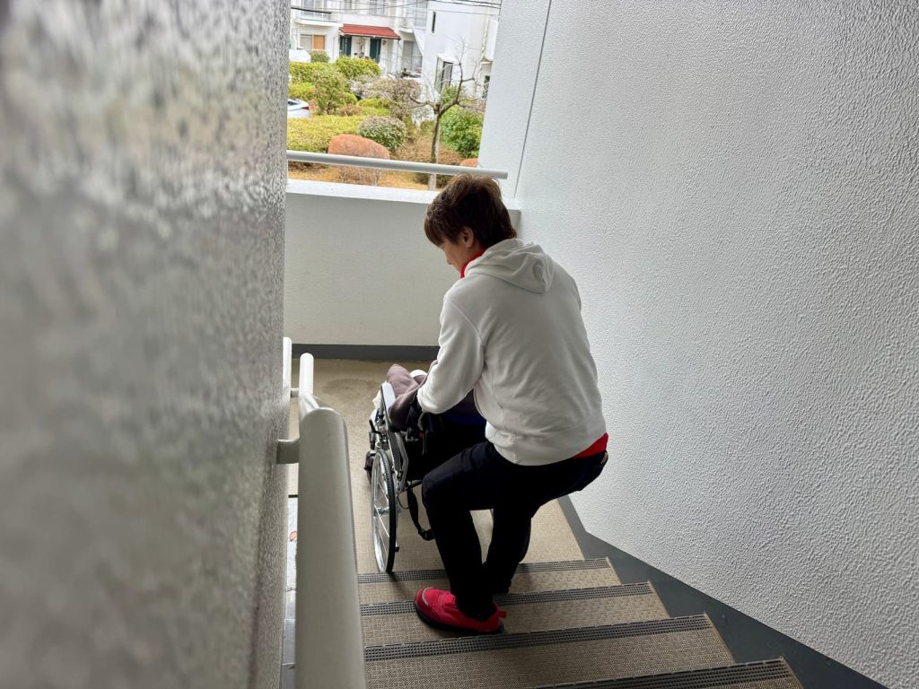 階段下から階段介助を始めるスタッフ