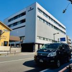 あけぼの病院の外観と福祉介護タクシー車両