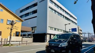 あけぼの病院の外観と福祉介護タクシー車両