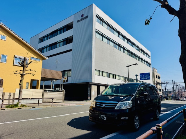 あけぼの病院の外観と福祉介護タクシー車両