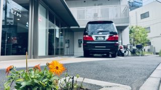 足立区にある特養老人ホームはなざかりの花壇にお花と奥に福祉介護タクシー車両