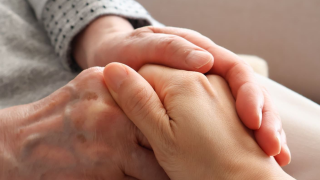 手を握り合い高齢者に安心感を与える