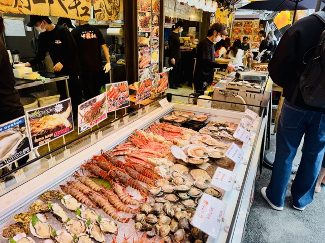築地場外市場商店街で貝・伊勢海老・ホタテ・カニなどの魚介類を販売するお店