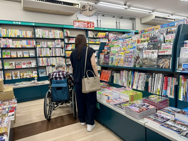 久美堂の本屋で本を買う車いすの高齢者と家族